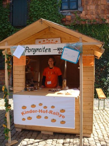 eine Verkaufshütte mit dem Hinweis auf Ponyreiten und einer Hof-Rallye